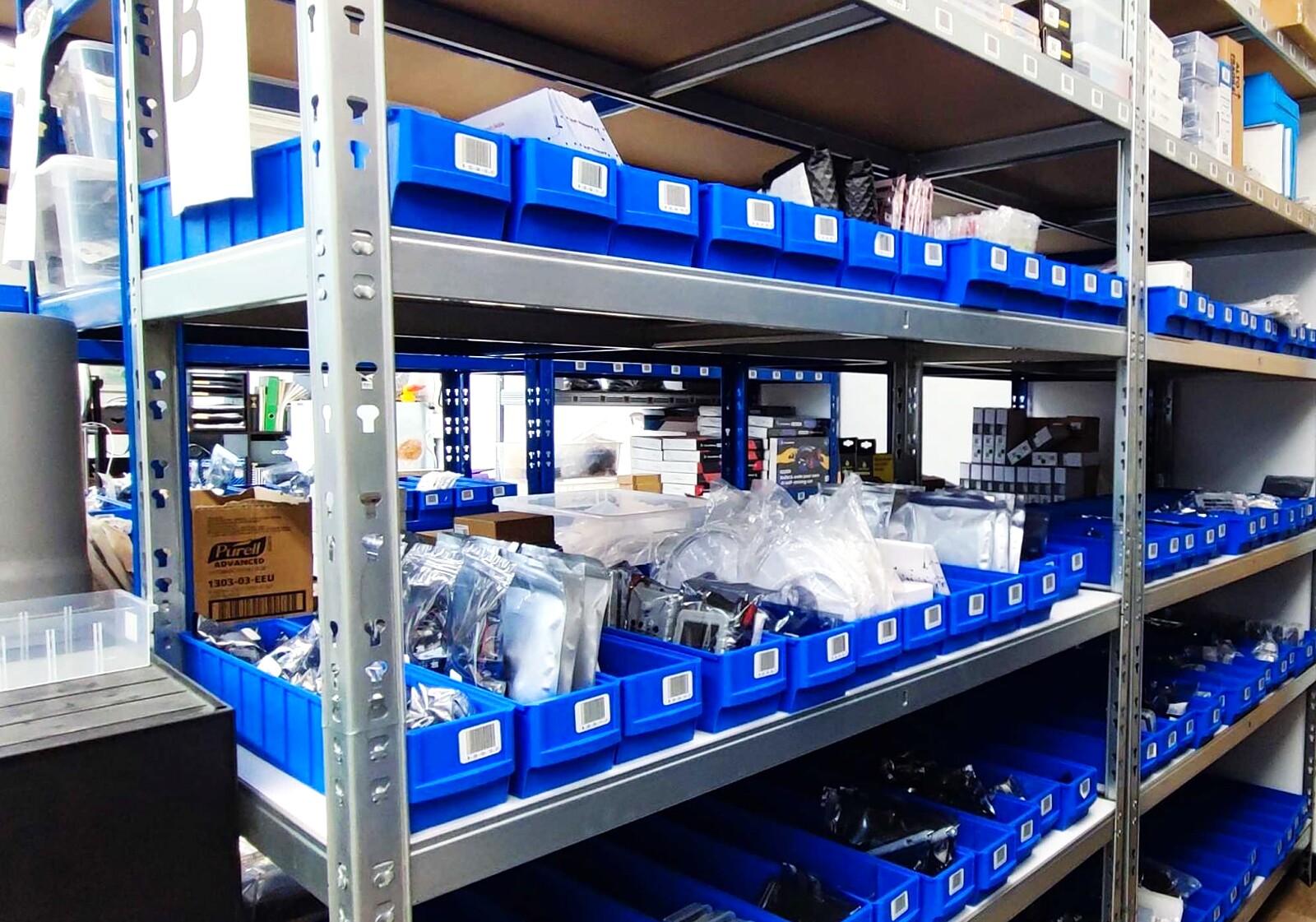 Shelving at ShopOfThings.ch in Lausen with blue open-fronted bins full of IoT hardware